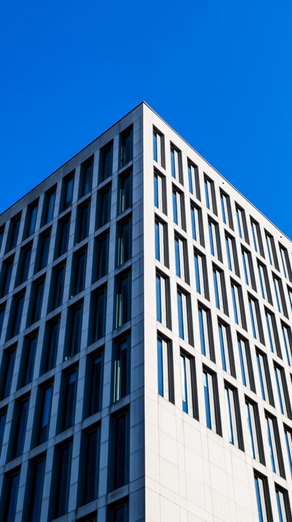 Contemporary high-rise building facade with blue sky backdrop highlighting minimalist architecture.